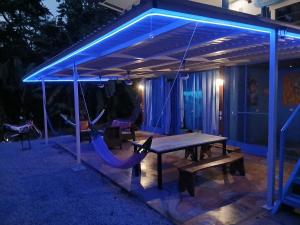 a ping pong table and chairs under a pavilion at night at Ocean View Modern dreamhouse 2 in Pavones +40 photos