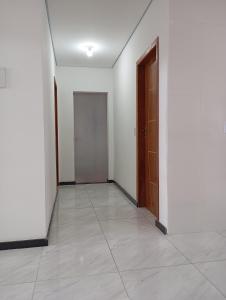 an empty hallway with a door and a tile floor at Casa para temporada in Prado