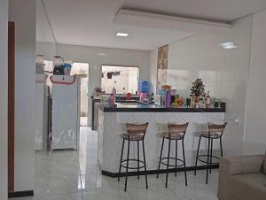 a kitchen with a counter and bar stools at Casa para temporada in Prado