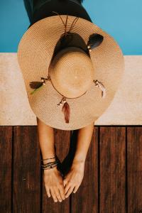 a person wearing a straw hat sitting on a wooden deck at Les Arbres Rouges in Sucé
