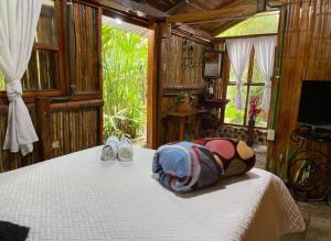 a bedroom with a bed with a backpack and shoes at Villa Sonia Eco-Hostel in Gigante