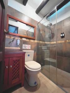 a bathroom with a toilet and a glass shower at Casa Real Barichara in Barichara