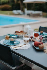 a table with plates of food on a table near a pool at Les Arbres Rouges in Sucé