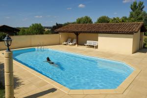 a person swimming in a large swimming pool at Camping le Cabri in Duras