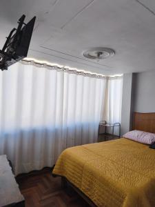 a bedroom with a bed and a white curtain at Titicaca Backpacker in Puno +30 photos