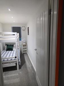 a small bedroom with a bunk bed and a door at Cozy Garden Apt - 8ight Havens in Folkestone +39 photos