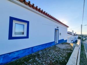 a blue and white house with a window at Refúgio de Monsaraz in Monsaraz