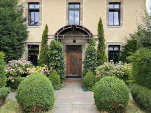 a house with a wooden door and some bushes at Boutique Apartment Benz 3 in Bergisch Gladbach
