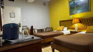 una camera d'albergo con due letti e un tavolo con un tavolo di Hotel Dinastía a San Cristóbal