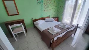 a bedroom with a bed with a mirror and a chair at Georgia's Summer House in Karianí
