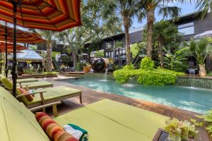 a pool at a hotel with chairs and an umbrella at Stylish Dallas Condo Resort-Style Pool in Dallas