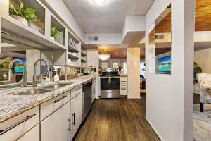 a large kitchen with white cabinets and wooden floors at Stylish Dallas Condo Resort-Style Pool in Dallas