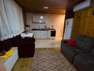 a living room with a couch and a kitchen at Casa Flores do Campo in Florianópolis