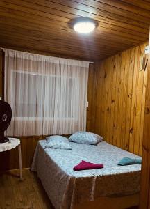 a bedroom with a bed in a room with a window at Casa Flores do Campo in Florianópolis