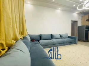 a blue couch in a living room with a curtain at Studio SAHRAOUI in Nouakchott