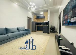 a living room with a blue couch and a kitchen at Studio SAHRAOUI in Nouakchott