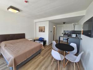 a bedroom with a bed and a table and chairs at Cerca de todo, monoambiente con parking in Montevideo