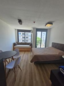 a room with two beds and a couch and a table at Cerca de todo, monoambiente con parking in Montevideo