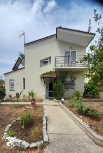 a white house with a balcony and a driveway at Georgia's Summer House in Karianí
