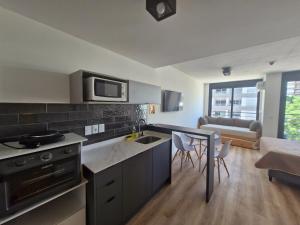 a kitchen with a sink and a table with chairs at Cerca de todo, monoambiente con parking in Montevideo