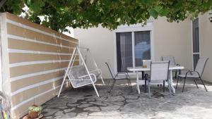 a table and chairs sitting next to a wall at Georgia's Summer House in Karianí +12 photos