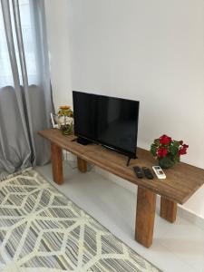 a television on a wooden table in a living room at Eco House1 in Santos