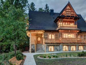 une grande maison en bois avec un toit en gambrel dans l'établissement Pokoje Gościnne Światłomir, à Zakopane