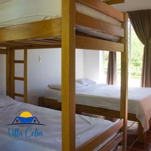 a bedroom with two bunk beds with white sheets at Villa Celia Casa Campo in Pueblo Bello