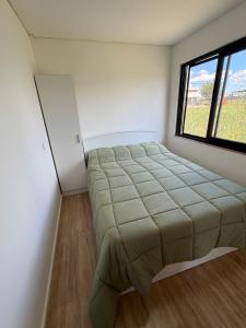 a bed in a room with a large window at Complejo Nomade Home in Marcos Juárez