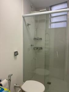 a bathroom with a glass shower with a toilet at Eco House1 in Santos