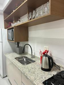 a kitchen counter with a sink and a microwave at Eco House1 in Santos