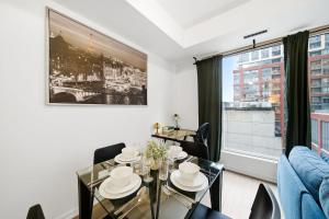 a living room with a table and chairs and a window at Spacious Condo with 2 Beds Unbeatable Location in Toronto