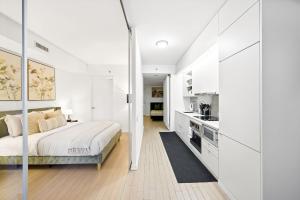 a white bedroom with a bed and a kitchen at Spacious Condo with 2 Beds Unbeatable Location in Toronto +26 photos