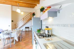 a kitchen with a stove and a table with chairs at Le Tartarughe Aparthotel in Letojanni
