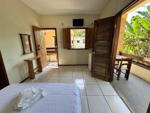 a bedroom with a bed and a view of a patio at Pousada Vila Verde in Olivença +43 photos