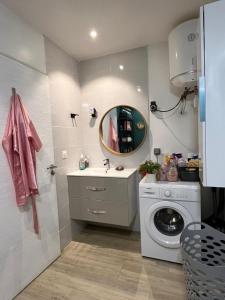a bathroom with a washing machine and a mirror at Bungalow Ti Paradis in Baie-Mahault