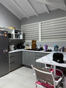a kitchen with a table and a counter top at Bungalow Ti Paradis in Baie-Mahault