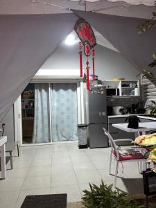 a kitchen with an angled ceiling with a refrigerator at Bungalow Ti Paradis in Baie-Mahault