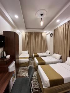 a hotel room with two beds and a television at فندق الدوبلي أجياد in Quai