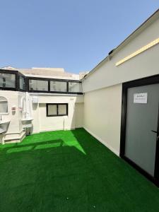 an empty garage with green grass on the floor at فندق الدوبلي أجياد in Quai