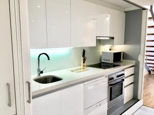 a white kitchen with a sink and a microwave at Panoramic Sea Suites II By VALENCIAFLATS EU in Valencia