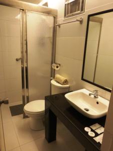 a bathroom with a sink and a toilet and a mirror at Silver Oaks Suites & Hotel in Manila +18 photos
