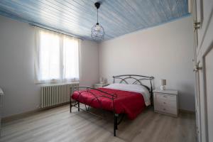 a bedroom with a bed with a red blanket at Casa Vacanze Leandra in San Costanzo