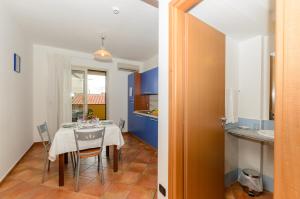 a kitchen and dining room with a table and chairs at Le Tartarughe Aparthotel in Letojanni +95 photos