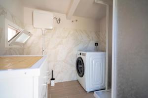 a laundry room with a washer and dryer at Casa Vacanze Leandra in San Costanzo