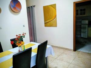 a dining room with a table with chairs and a painting at Villa Julien 2 chambres in Rufisque