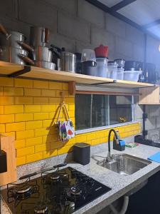 eine Küche mit Spüle und Arbeitsplatte in der Unterkunft Rustica e Charmosa in Santa Cruz Cabrália