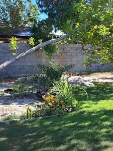 ein Garten mit Blumen und eine Backsteinmauer in der Unterkunft Rustica e Charmosa in Santa Cruz Cabrália