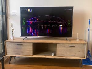 a flat screen tv on a wooden entertainment center at Boxhill home in Box Hill