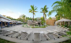 a group of lounge chairs and a fountain at a resort at Centara Karon Villas Phuket in Karon Beach